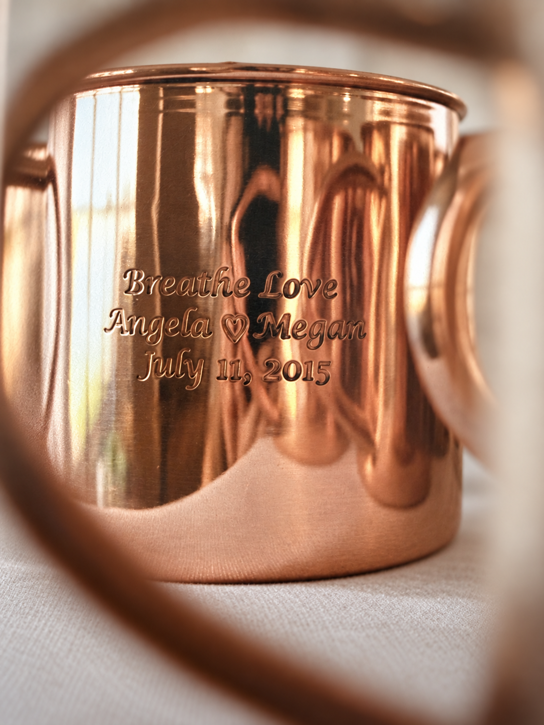 Copper wedding mug engraved with Breathe Love, Angela and Megan’s names, and their wedding date.